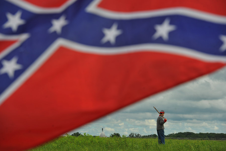 Dressed as a Confederate soldier, Rocco Smith, 12, stands off by himself as people gather prior to a march to mark the anniversary of Pickett's Charge at Gettysburg National Military Park on Wednesday July 03, 2013 in Gettysburg, PA. People have flocked to the town to commemorate the 150th anniversary of the Battle of Gettysburg. The battle is considered a turning point in the Civil War. (Photo by Matt McClain/ The Washington Post)