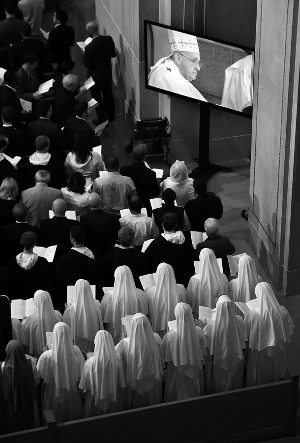 Attendees within the Basilica of the National Shrine of the Immaculate Conception watch Pope Francis on screens as he leads a mass outside on Wednesday September 23, 2015 in Washington, DC. (Photo by Matt McClain/The Washington Post)