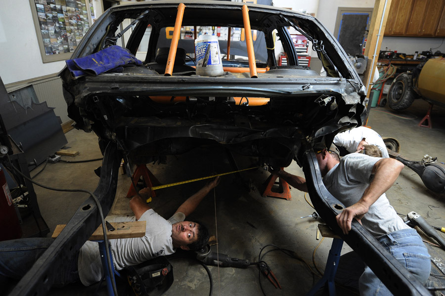 Bill Orndorff, left, works with his friend, Herbie Polhemus, right, and his son, Josh Orndorff, far right, on his oldest son's demolition derby car at the family's home on Tuesday August 21, 2012 in Woodstock, VA.  Bill and Zach both competed in the first night of the demolition derby of the Shenandoah County Fair.  Bill won the main event in the second derby night.