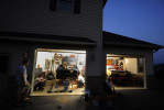 Zach Orndorff, left, and his brother, Josh Orndorff, left center, watch their father Bill Orndorff, center, work on Zach's demolition derby car at the family's Woodstock, VA home on Tuesday August 21, 2012 in Woodstock, VA.  