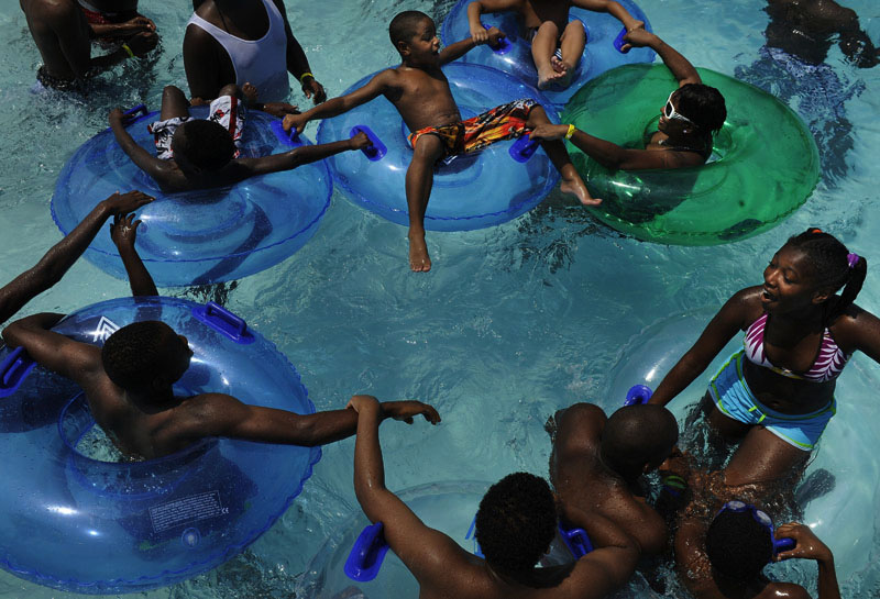 Keeping cool in the heat, Tatiyana Allen, 12, far right, plays in the water with others at Great Waves Waterpark at Cameron Run Regional Park on Friday July 29, 2011 in Alexandria, VA. Temperatures in the area exceeded 100 degrees. (Photo by Matt McClain/For The Washington Post)
