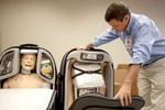 John Massie, assistant director of sports medicine at the Student Health Center at Southern Illinois University Carbondale, unzips a suitcase holding the legs of SimMan 3G, a simulation mannequin shipped to SIUC from Southern Illinois University Edwardsville, in Carbondale, Ill. 