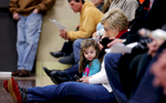 Emily Pearce, 3, welcomes a distraction during a packed meeting about the dwindling school district budget at Cherry Grade School in Cherry, Ill. 