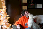 John McKirgan pets his dog, Angel, at his home outside Peru, Ill. On the wall behind him are the medals he was awarded after his Army service in Iraq, including a Purple Heart. 