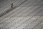 A member of the Southern Illinois University Carbondale track team runs the bleachers during a hot afternoon practice in Carbondale, Ill. 